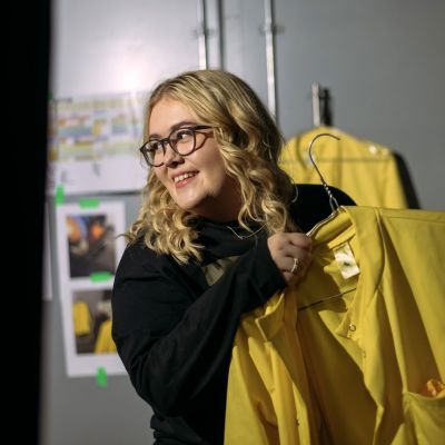 Costume student carrying costumes to set